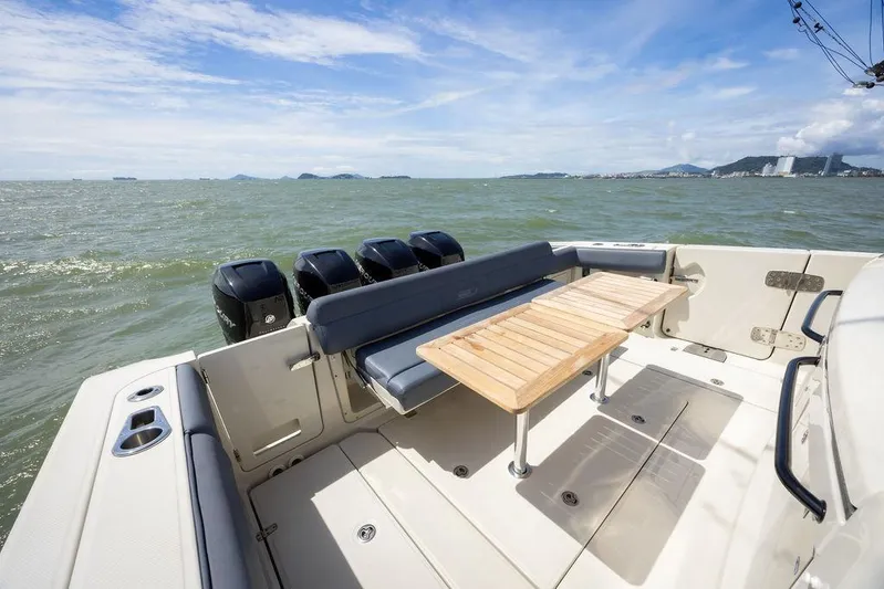 Pachanga Yacht Photos Pics 2021 Boston Whaler 420 Outrage boat deck with seating and table, ocean view.