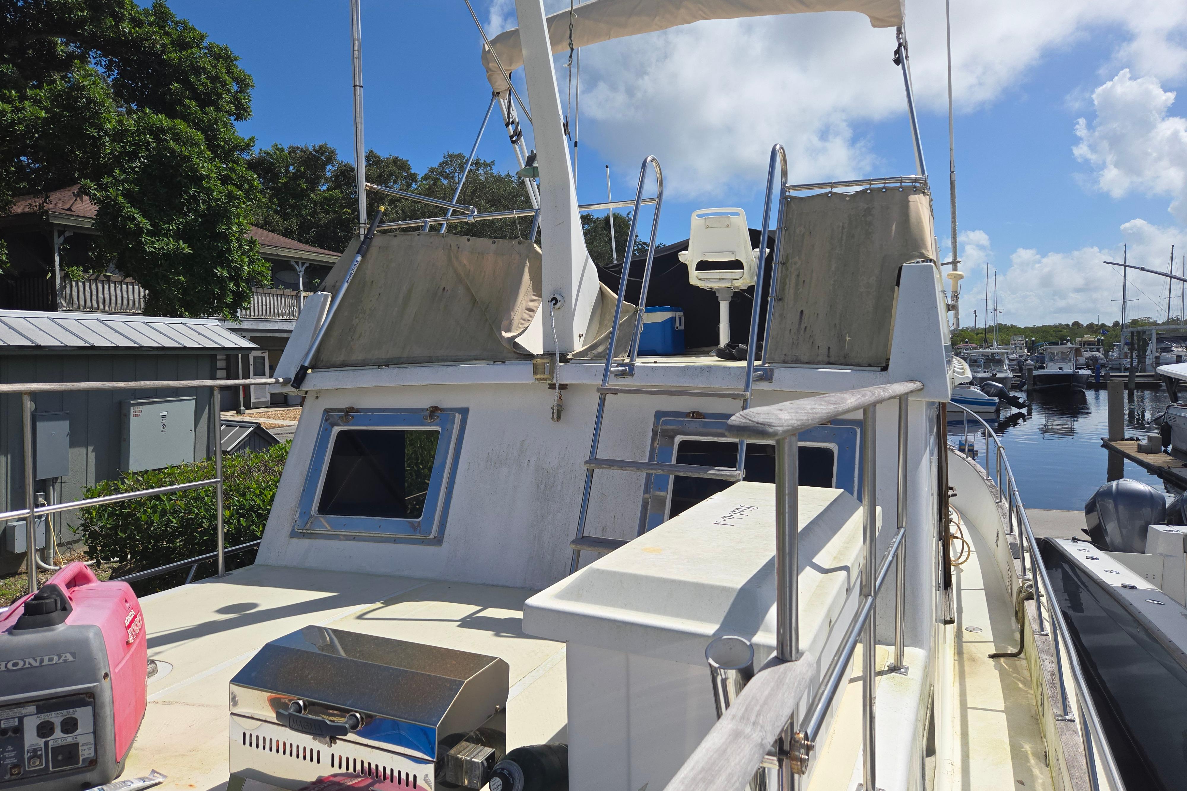 1983 Custom Present 38 Double Cabin Trawler docked at marina under clear blue sky.