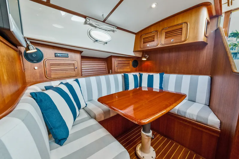 Skylark Yacht Photos Pics Interior of 2008 Hinckley Talaria 44 yacht with striped seating and wooden table.