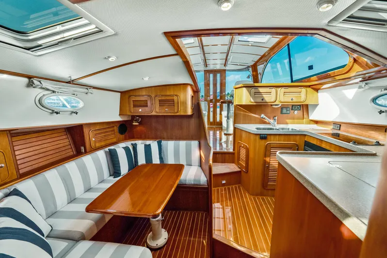 Skylark Yacht Photos Pics Luxurious interior of 2008 Hinckley Talaria 44 yacht with wood finishes and striped seating.