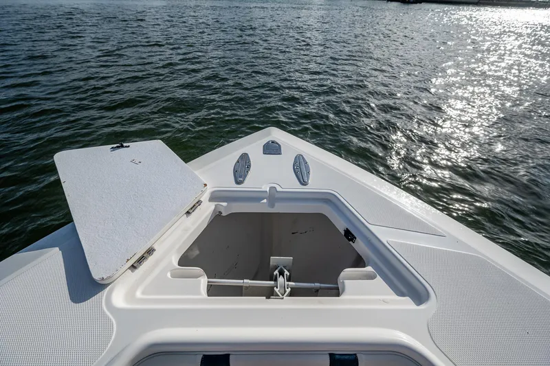 Poliseas Yacht Photos Pics Bow of 2006 Bahama 31 boat with open hatch, on calm water.