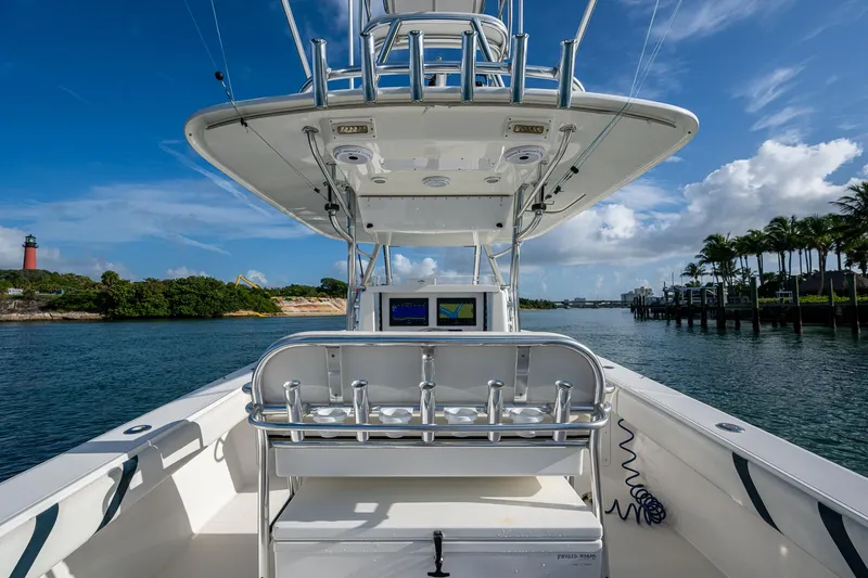 Poliseas Yacht Photos Pics 2006 Bahama 31 boat on water, clear sky, lighthouse, and palm trees in the background.