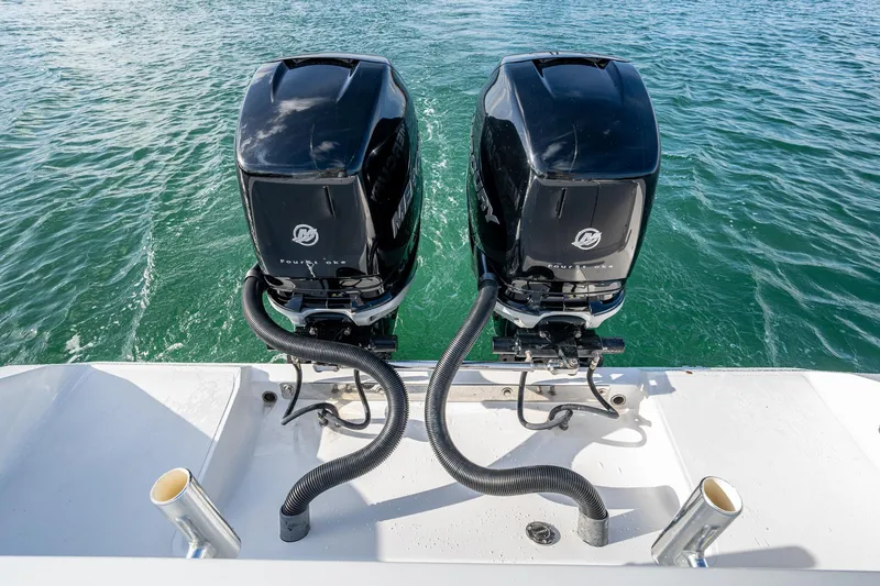 Poliseas Yacht Photos Pics Twin Mercury outboard engines on a 2006 Bahama 31 boat, floating on clear water.