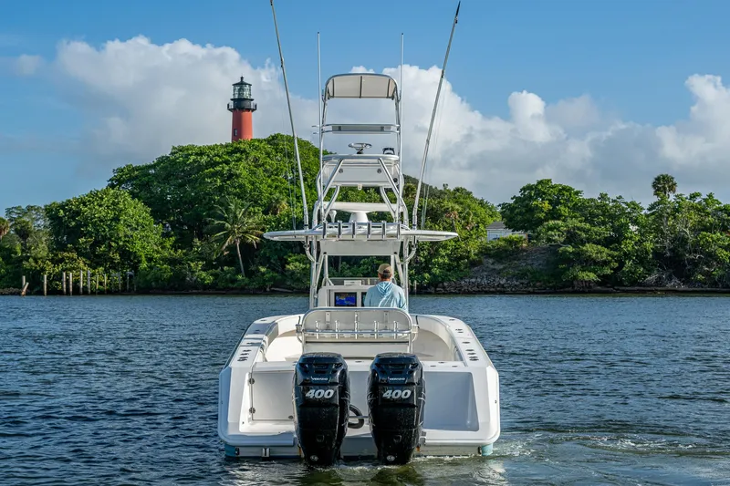 Poliseas Yacht Photos Pics 2006 Bahama 31 boat on water near lush greenery and lighthouse.
