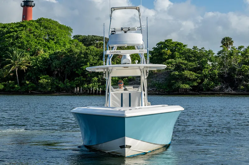 Poliseas Yacht Photos Pics 2006 Bahama 31 boat cruising on water with lush greenery and lighthouse in background.