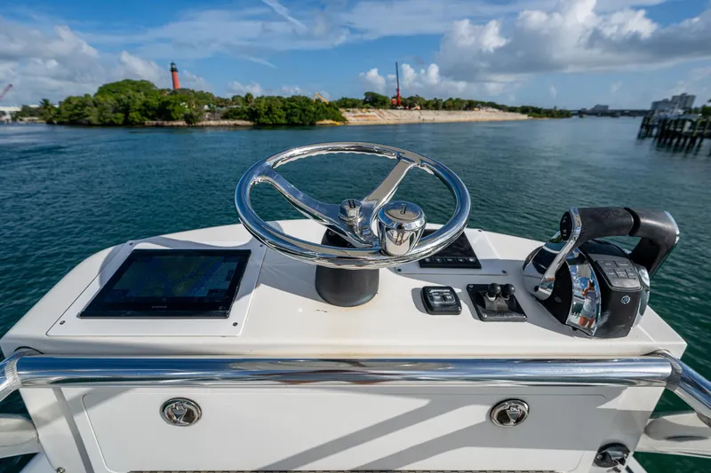 Poliseas Yacht Photos Pics Helm of 2006 Bahama 31 boat with steering wheel and controls, overlooking scenic waterway.