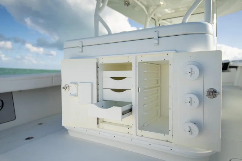  Yacht Photos Pics 2022 Yellowfin 39 Offshore boat storage compartment with open drawers under a clear sky.