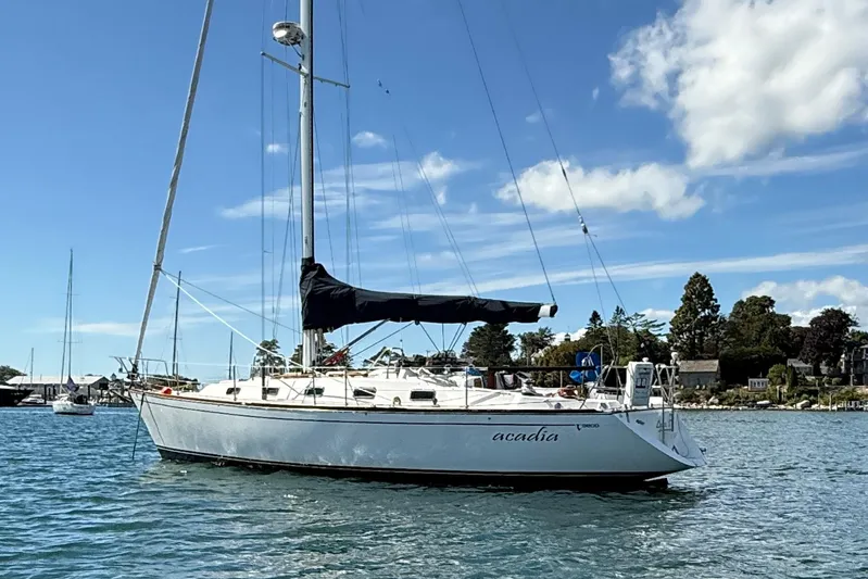 Acadia Yacht Photos Pics Sailboat Tartan 3800, 1997 model, anchored on a sunny day with blue skies.