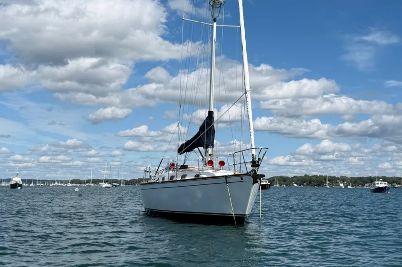 Acadia Yacht Photos Pics Sailboat Tartan 3800, 1997 model, anchored on a sunny day with scattered clouds.