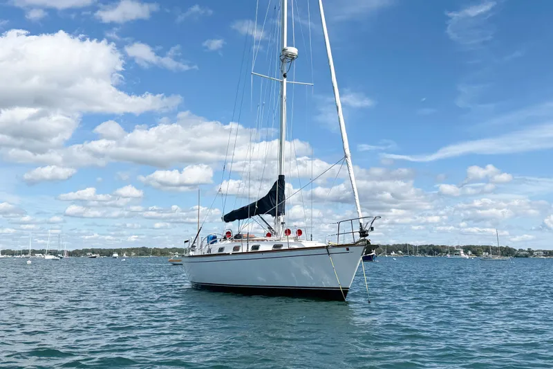 Acadia Yacht Photos Pics Sailboat Tartan 3800, 1997 model, anchored on a sunny day with blue skies.