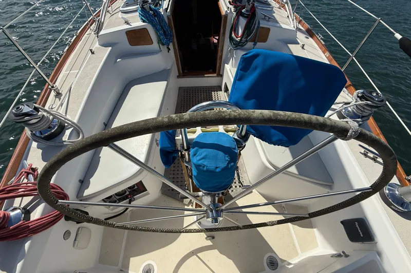 Acadia Yacht Photos Pics Cockpit of 1997 Tartan 3800 sailboat with steering wheel and blue covers.