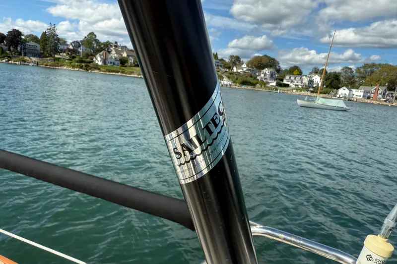 Acadia Yacht Photos Pics Sailboat mast on Tartan 3800, 1997 model, with coastal houses in the background.