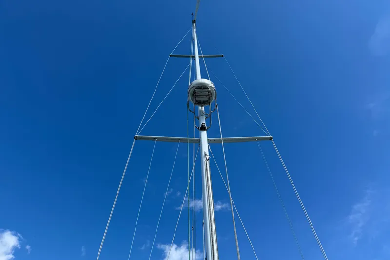 Acadia Yacht Photos Pics Tall mast of 1997 Tartan 3800 sailboat against clear blue sky.