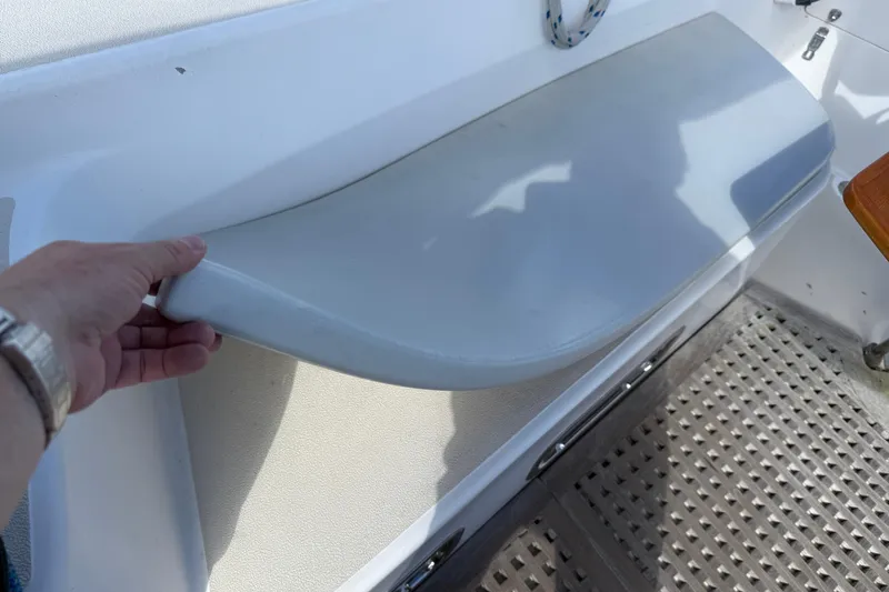 Acadia Yacht Photos Pics Hand lifting seat on 1997 Tartan 3800 boat, showcasing interior design details.