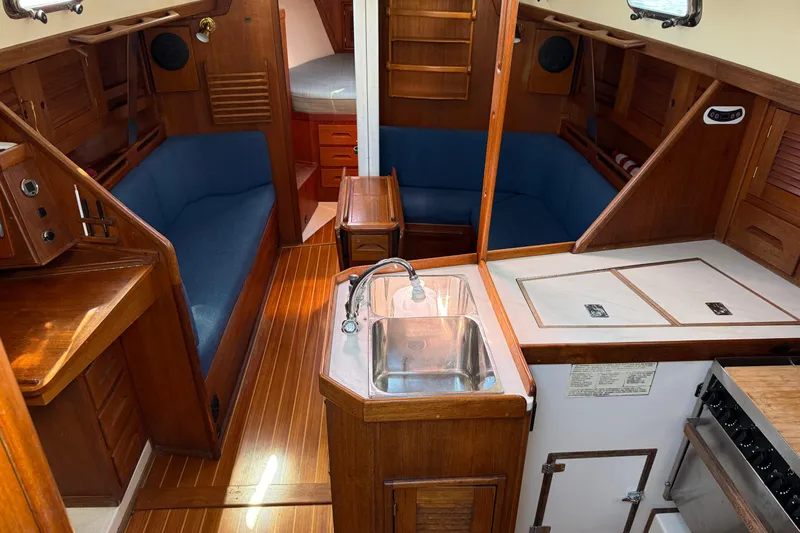 Acadia Yacht Photos Pics Interior of a 1997 Tartan 3800 sailboat with wood finish and blue seating.
