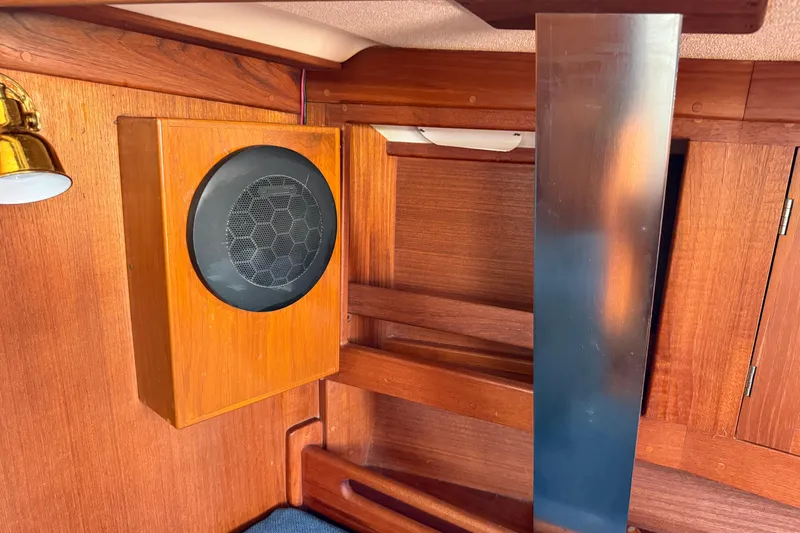 Acadia Yacht Photos Pics Wooden interior of a 1997 Tartan 3800 sailboat with speaker and metal panel.