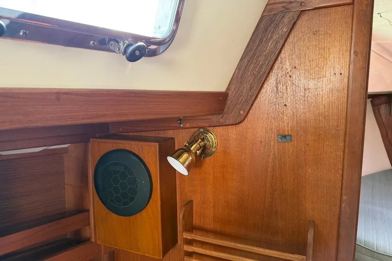 Acadia Yacht Photos Pics Interior of a 1997 Tartan 3800 sailboat featuring wooden paneling and a brass light fixture.