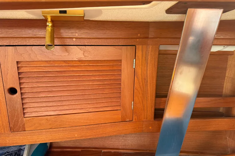 Acadia Yacht Photos Pics Wooden interior of a 1997 Tartan 3800 sailboat with brass and metal accents.
