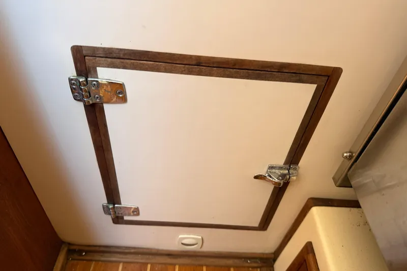 Acadia Yacht Photos Pics Hinged wooden hatch door inside a 1997 Tartan 3800 boat interior.