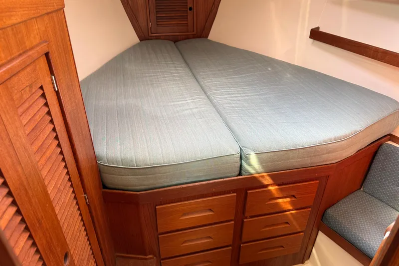 Acadia Yacht Photos Pics Cozy cabin interior of 1997 Tartan 3800 sailboat with wooden storage and cushioned bed.