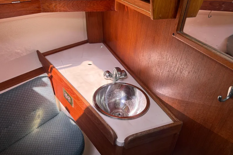 Acadia Yacht Photos Pics Interior of 1997 Tartan 3800 yacht with wooden cabinetry and stainless steel sink.