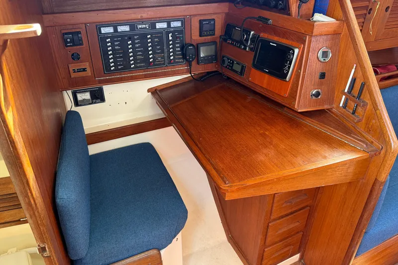 Acadia Yacht Photos Pics Navigation station in a 1997 Tartan 3800 sailboat with wooden desk and control panel.