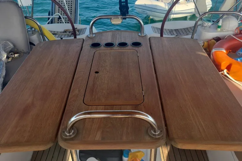  Yacht Photos Pics Cockpit table on 2009 Jeanneau Sun Odyssey 50 DS sailboat, featuring wooden finish and cup holders.