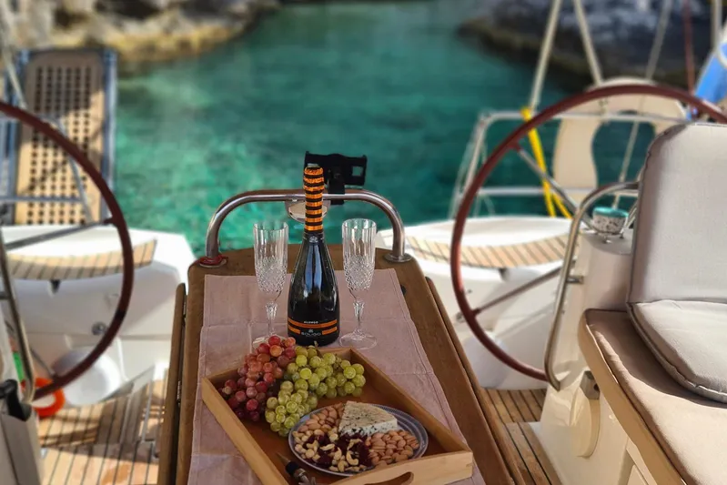  Yacht Photos Pics Luxury dining setup on Jeanneau Sun Odyssey 50 DS yacht, featuring wine and snacks.