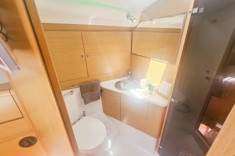  Yacht Photos Pics Luxurious bathroom in 2009 Jeanneau Sun Odyssey 50 DS yacht, featuring modern fixtures and wood cabinetry.