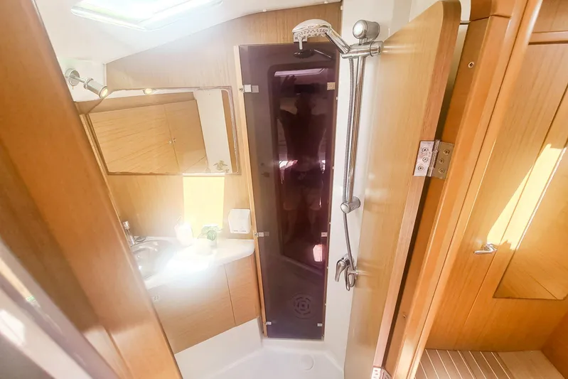  Yacht Photos Pics 2009 Jeanneau Sun Odyssey 50 DS bathroom with shower, wooden cabinetry, and mirror.
