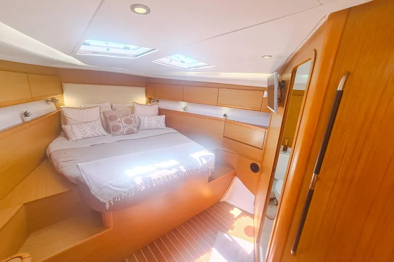  Yacht Photos Pics Luxurious cabin interior of 2009 Jeanneau Sun Odyssey 50 DS yacht, featuring cozy bed and skylights.