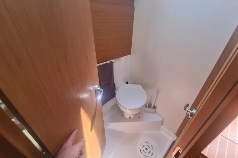  Yacht Photos Pics 2009 Jeanneau Sun Odyssey 50 DS yacht bathroom with compact toilet and wooden door.