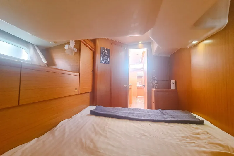  Yacht Photos Pics Interior cabin of 2009 Jeanneau Sun Odyssey 50 DS yacht, featuring cozy wooden design.