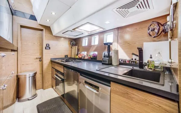 Euphoria Yacht Photos Pics Modern kitchen interior on 2016 Sunreef 60 LOFT yacht, featuring sleek wood and stainless steel finishes.