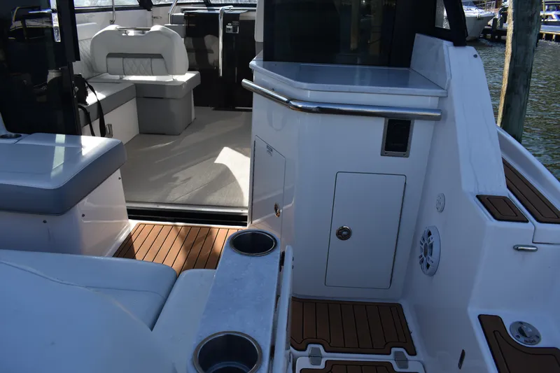  Yacht Photos Pics 2024 Regal 36 XO boat interior with seating and wood flooring, docked at marina.