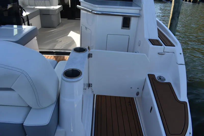  Yacht Photos Pics 2024 Regal 36 XO boat interior with seating and cup holders, docked by water.
