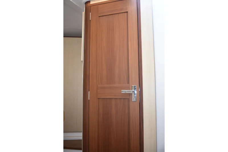  Yacht Photos Pics Wooden cabin door inside 2024 Regal 36 XO yacht, featuring sleek design and modern handle.
