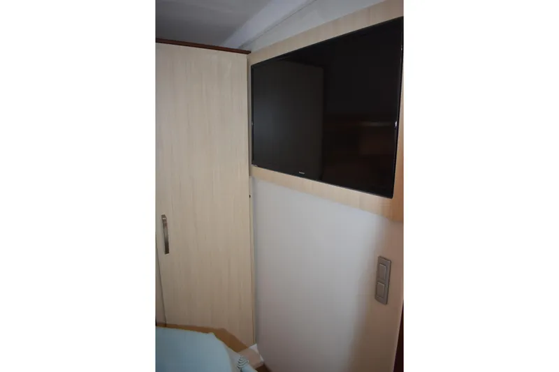  Yacht Photos Pics 2024 Regal 36 XO interior with wall-mounted TV and wooden cabinet.
