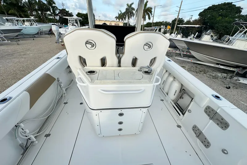  Yacht Photos Pics 2021 Edgewater 262CC boat interior with seating and storage, docked outdoors.