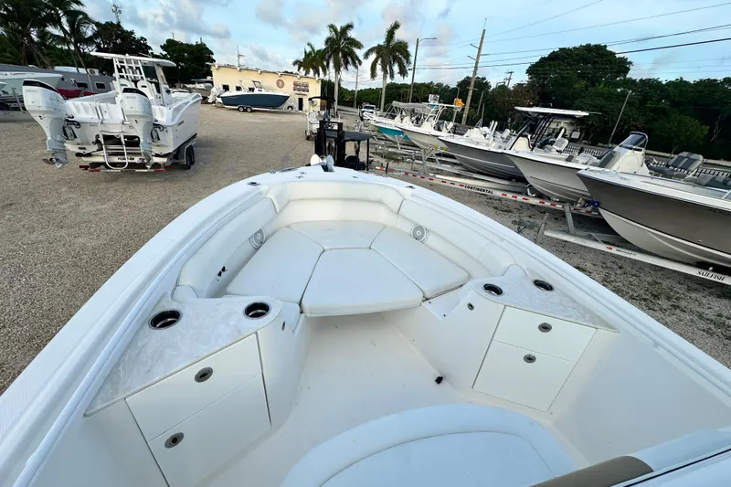  Yacht Photos Pics 2021 Edgewater 262CC boat interior with seating and cup holders, parked among other boats.