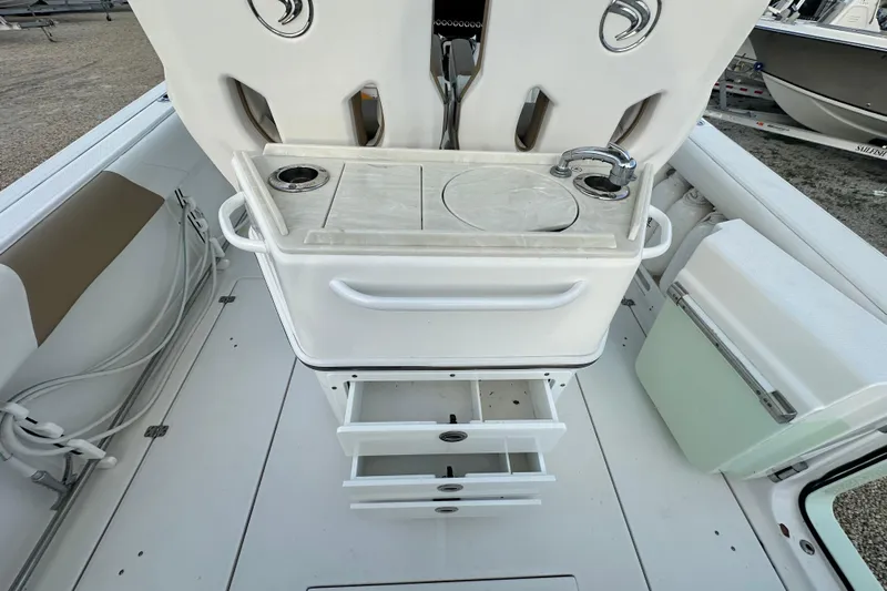  Yacht Photos Pics 2021 Edgewater 262CC boat interior with sink, storage drawers, and seating area.