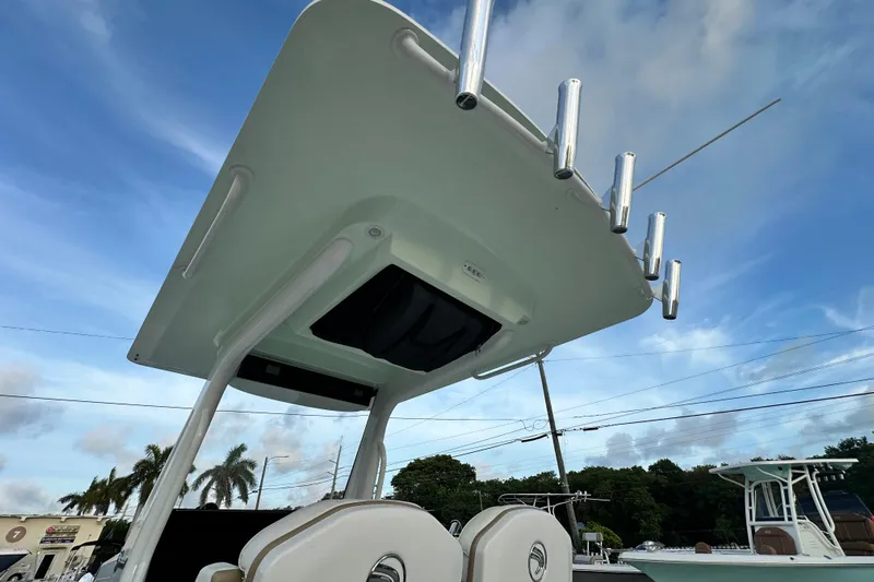  Yacht Photos Pics 2021 Edgewater 262CC boat with T-top and rod holders against a blue sky.
