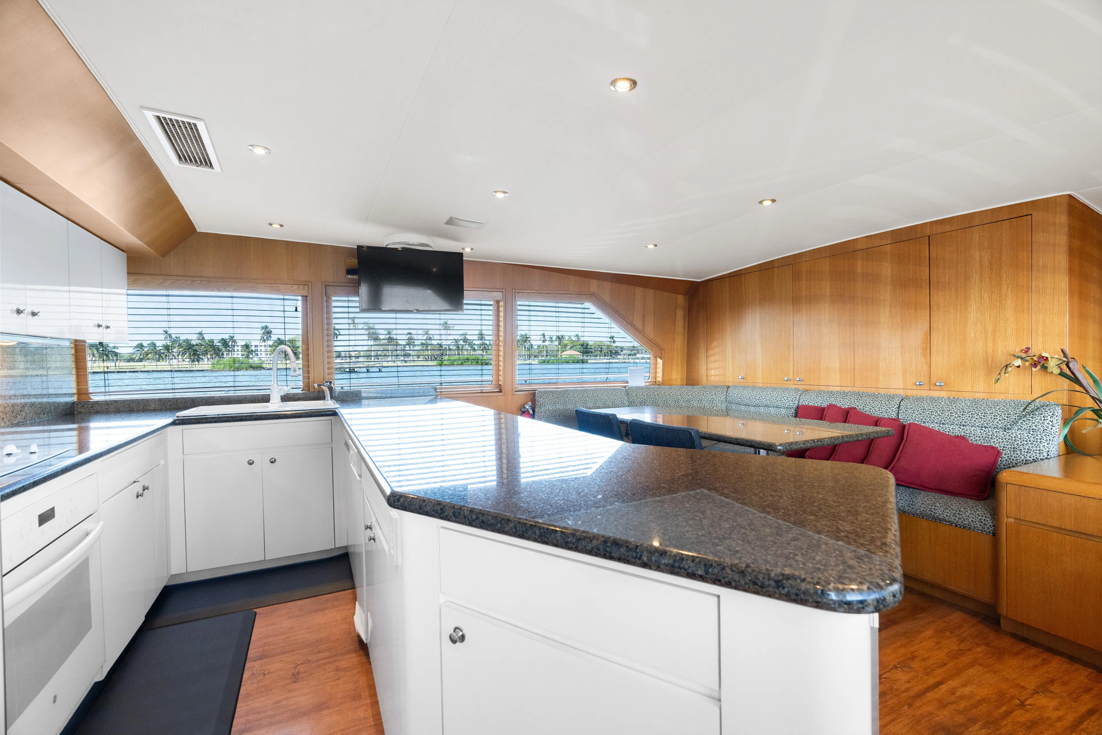 Crown Jewel Yacht Photos Pics Luxurious interior of 1996 Broward 96 Raised Pilothouse MY yacht with modern kitchen and seating area.