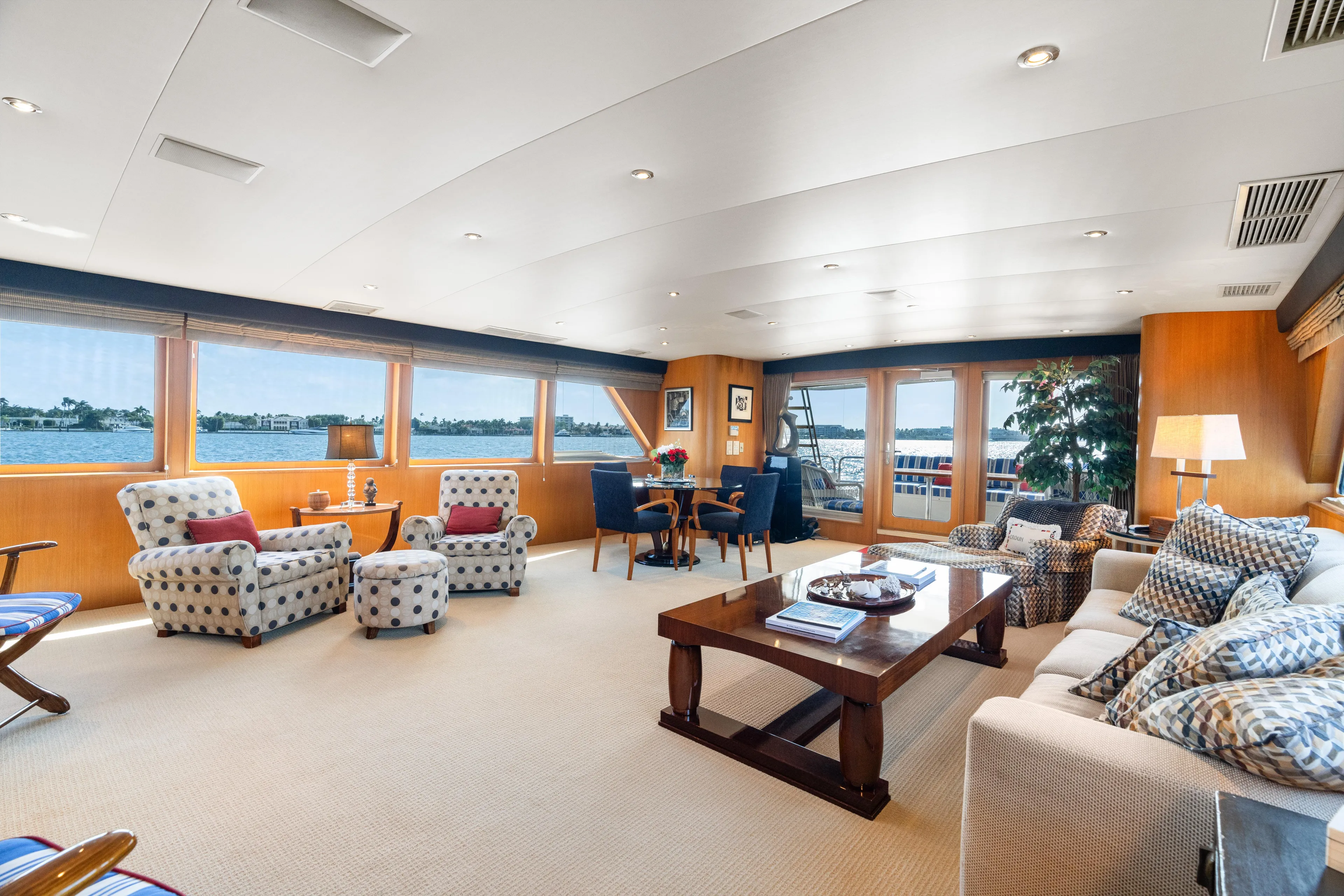 Crown Jewel Yacht Photos Pics Luxurious interior of 1996 Broward 96 Raised Pilothouse MY yacht with elegant seating and large windows.