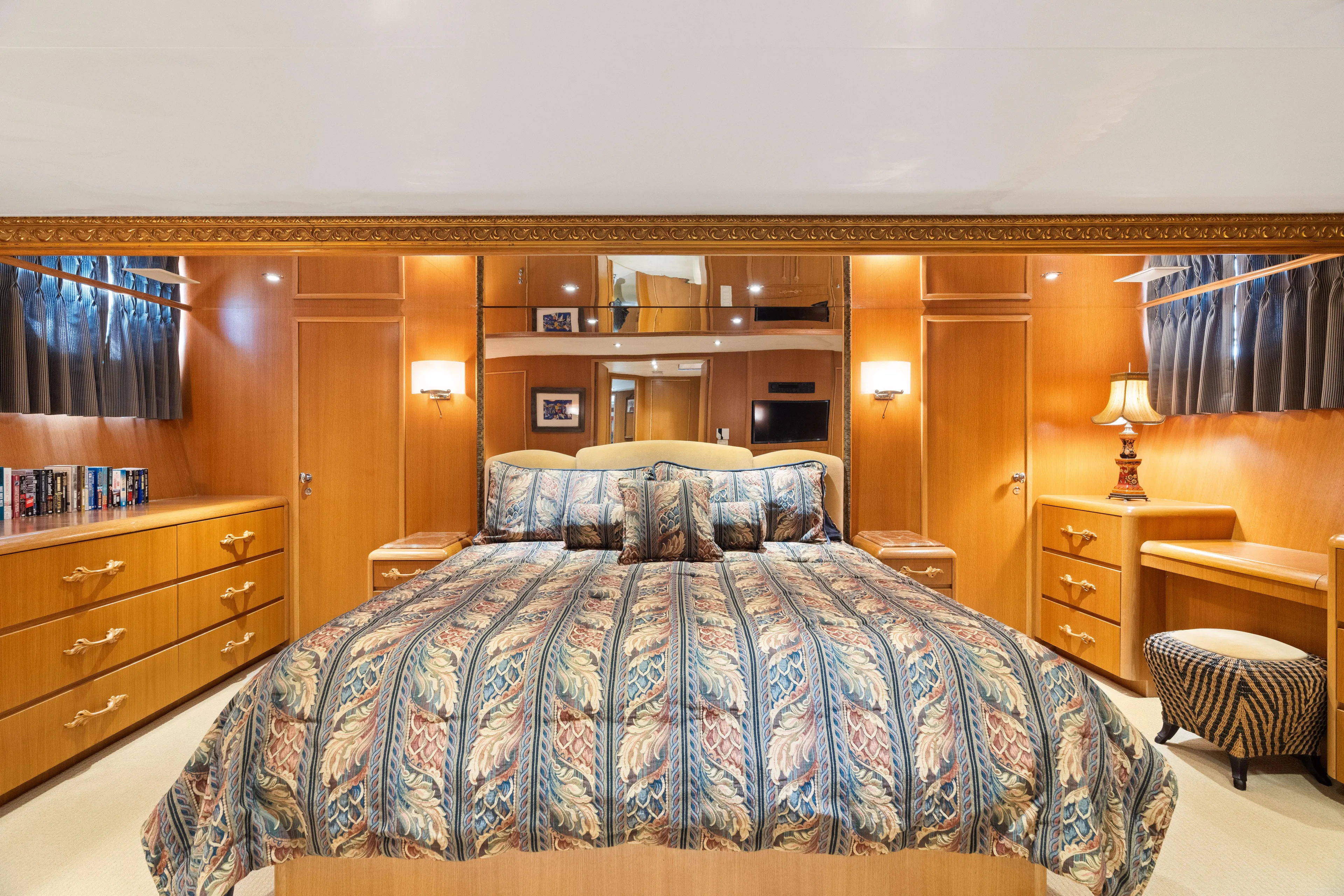 Crown Jewel Yacht Photos Pics Luxurious bedroom in 1996 Broward 96 Raised Pilothouse MY yacht, featuring elegant wood furnishings.