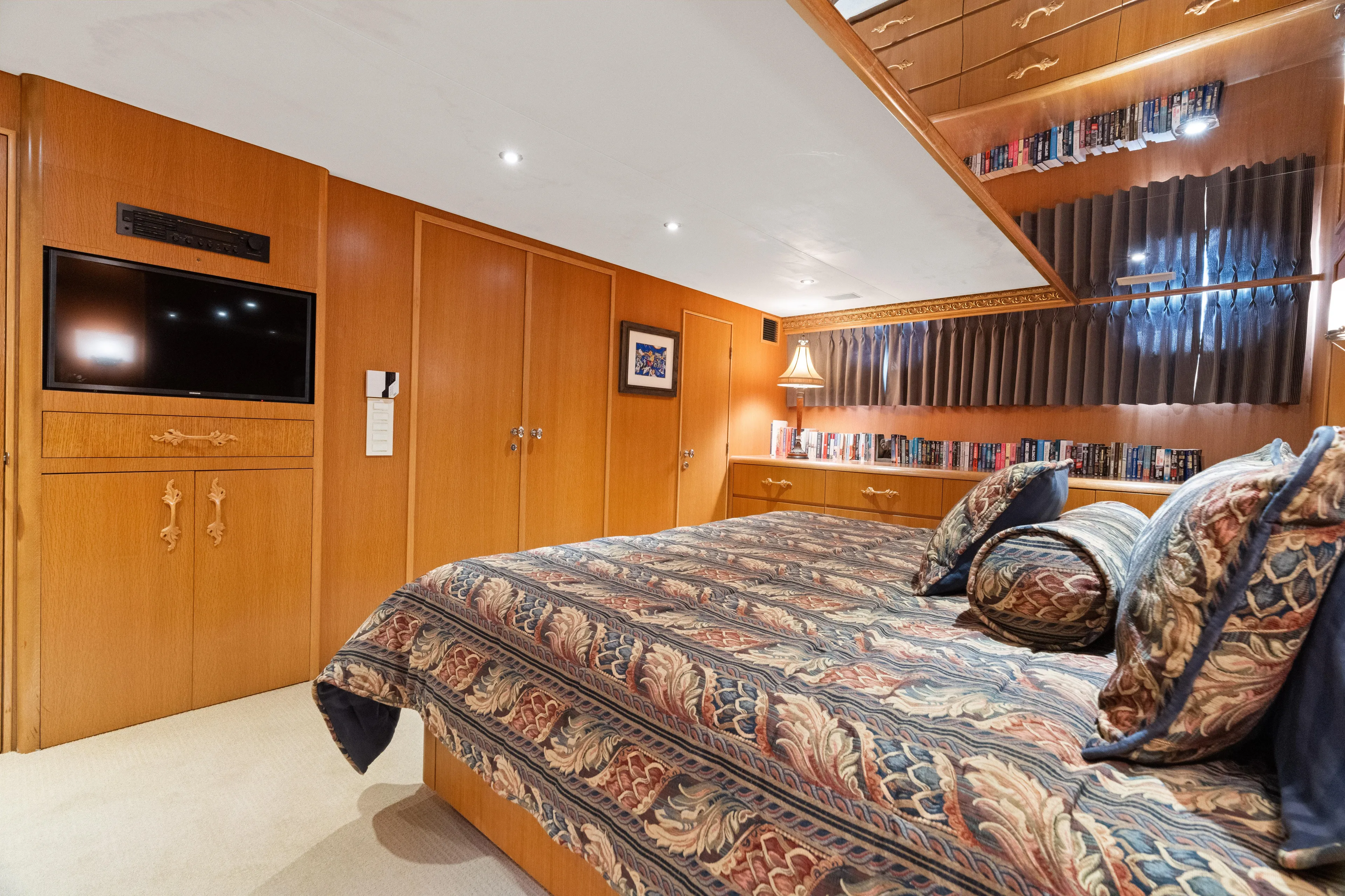 Crown Jewel Yacht Photos Pics Luxurious bedroom in 1996 Broward 96 Raised Pilothouse MY yacht with elegant wood paneling.