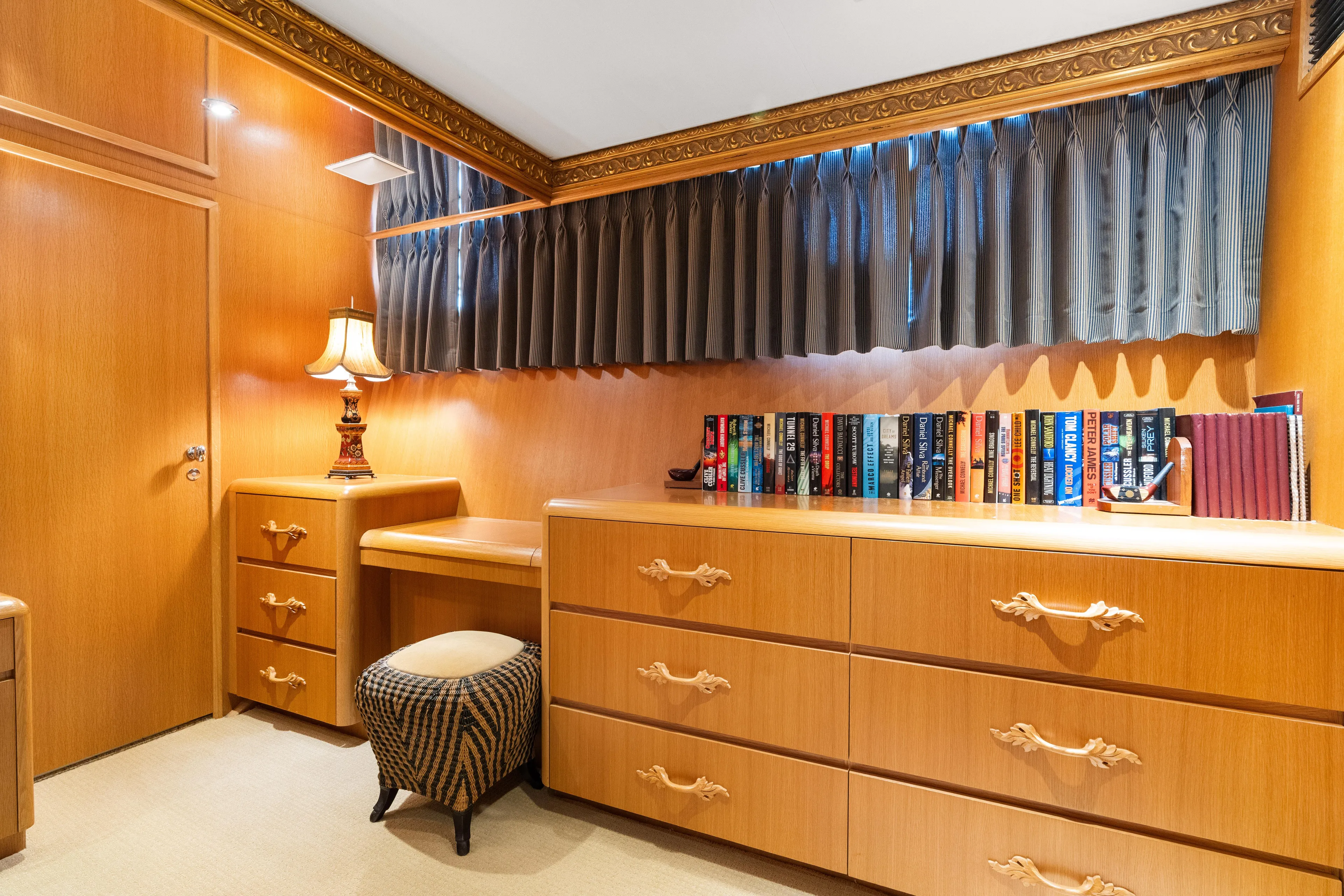 Crown Jewel Yacht Photos Pics Luxurious wooden interior of 1996 Broward 96 Raised Pilothouse MY yacht with books and lamp.