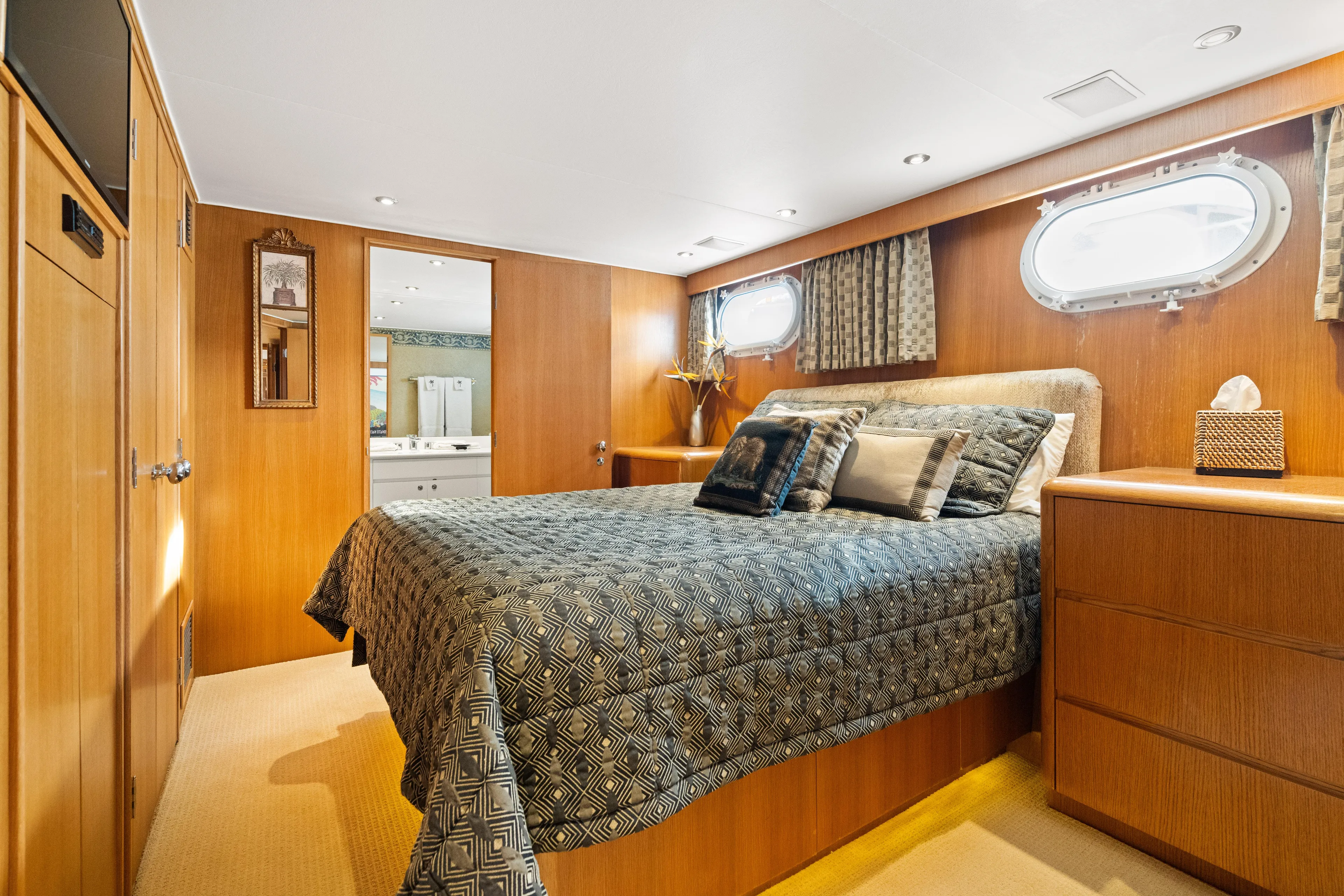 Crown Jewel Yacht Photos Pics Luxurious bedroom in 1996 Broward 96 Raised Pilothouse MY yacht, featuring elegant wood paneling.