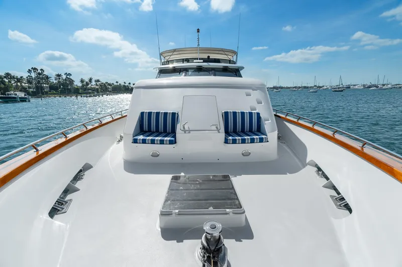 Crown Jewel Yacht Photos Pics Luxury 1996 Broward 96 Raised Pilothouse yacht on serene water, featuring striped seating.