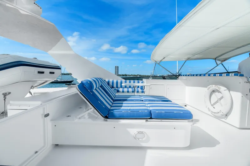 Crown Jewel Yacht Photos Pics Luxury yacht deck with blue-striped lounge seating, Broward 96 Raised Pilothouse MY, 1996 model.